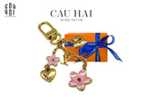 MÓC KHOÁ – CHARM TÚI CHERRY BLOSSOM BY LOUIS.V FULLBOX-CẬU HAI HOME DECOR